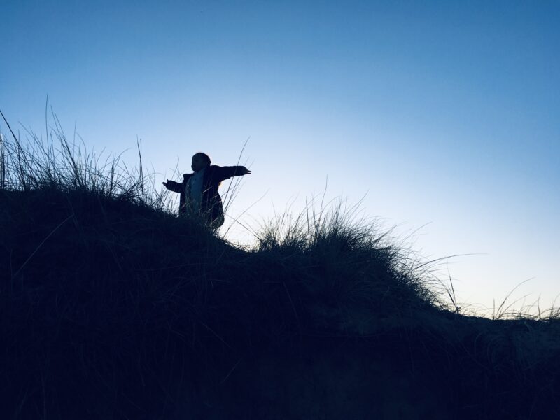 silhouette of child on a hill