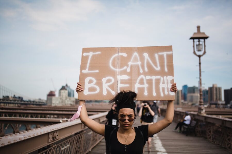 Photo Of Woman Carrying A Cardboard "I can't breathe" sign